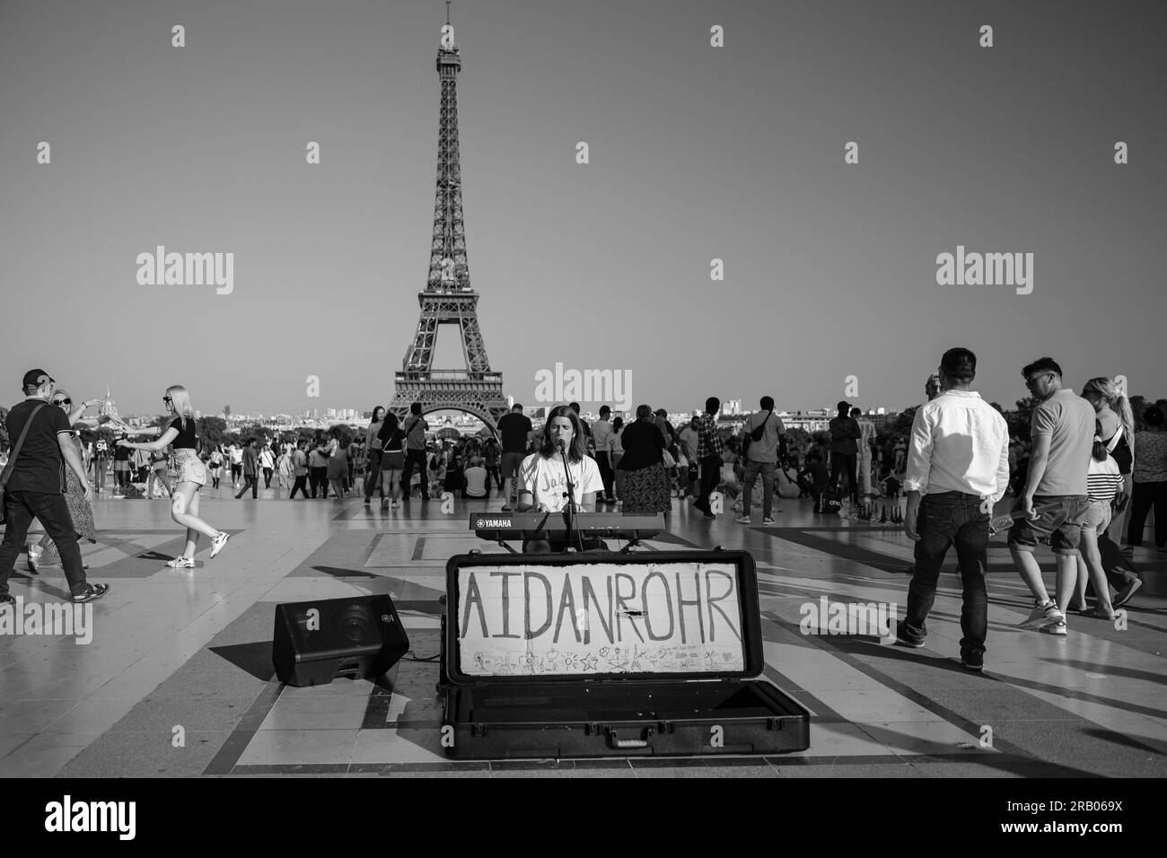 Paris, France - 25 juin 2023 : vue d'un musicien de rue jouant de la musique devant la Tour Eiffel à Paris France en noir et blanc Banque D'Images