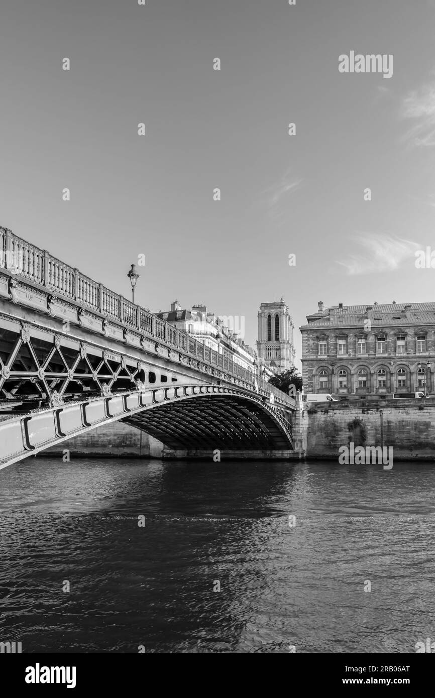 Paris, France - 25 juin 2023 : vue sur un magnifique pont, la Seine et la célèbre cathédrale notre Dame de Paris en noir et blanc Banque D'Images