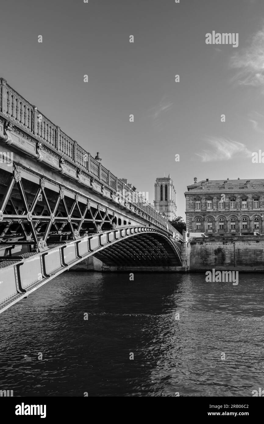 Paris, France - 25 juin 2023 : vue sur un magnifique pont, la Seine et la célèbre cathédrale notre Dame de Paris en noir et blanc Banque D'Images