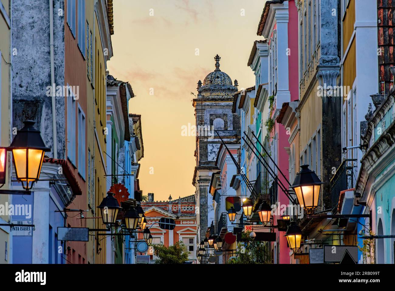 Rue avec des maisons historiques avec leurs façades et lanternes dans le quartier Pelourinho à Salvador au coucher du soleil Banque D'Images
