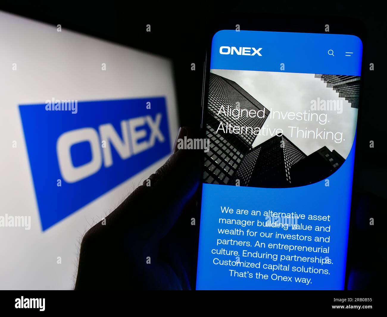 Personne détenant un téléphone intelligent avec le site Web de la société de placement canadienne Onex Corporation à l'écran avec logo. Concentrez-vous sur le centre de l'écran du téléphone. Banque D'Images