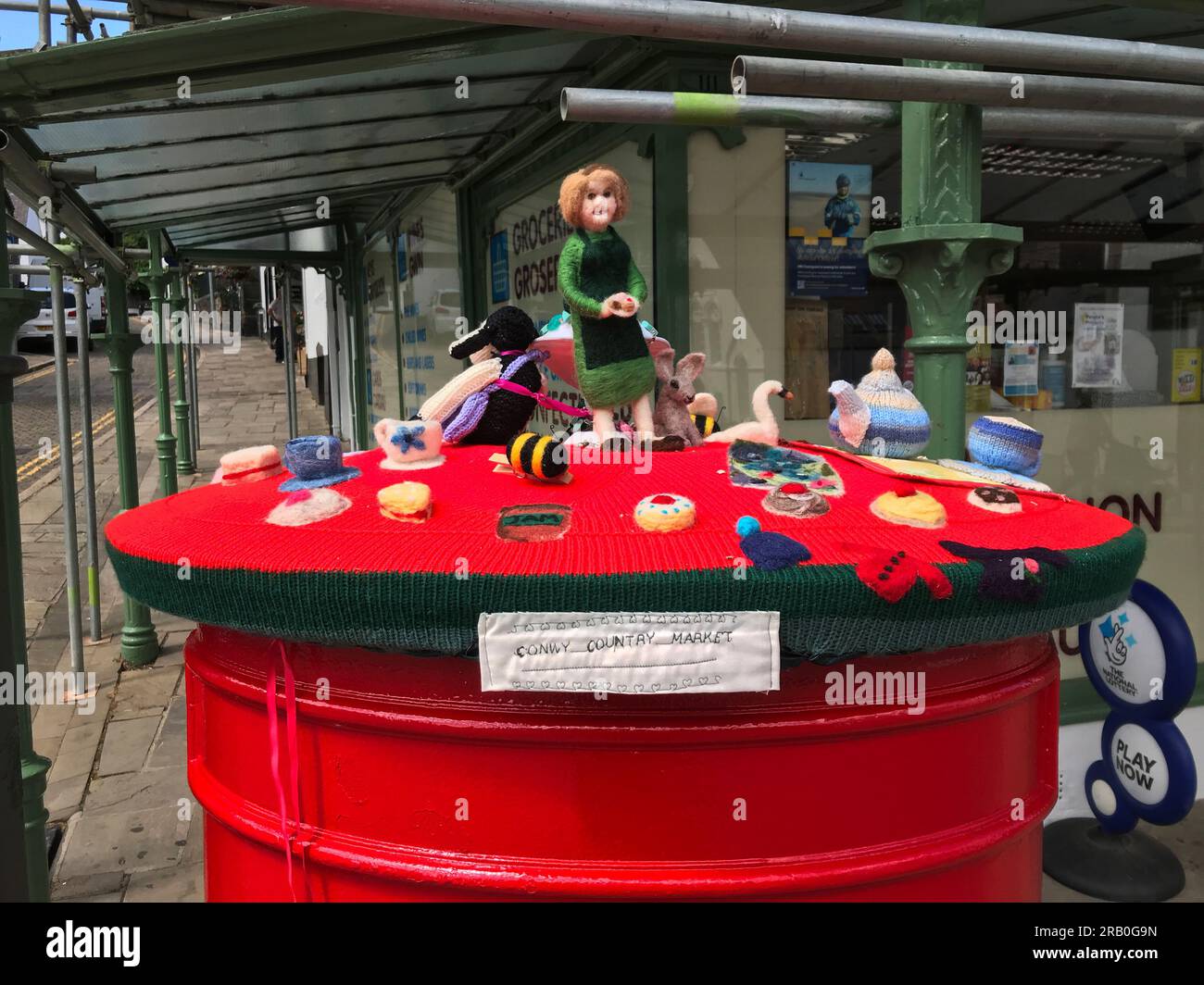 Tricot boîte aux lettres / surmontoir de boîte aux lettres crocheté célébrant les biens et les gens du Conwy Country Market, Conwy Square, les arts et l'artisanat locaux du nord du pays de Galles Banque D'Images