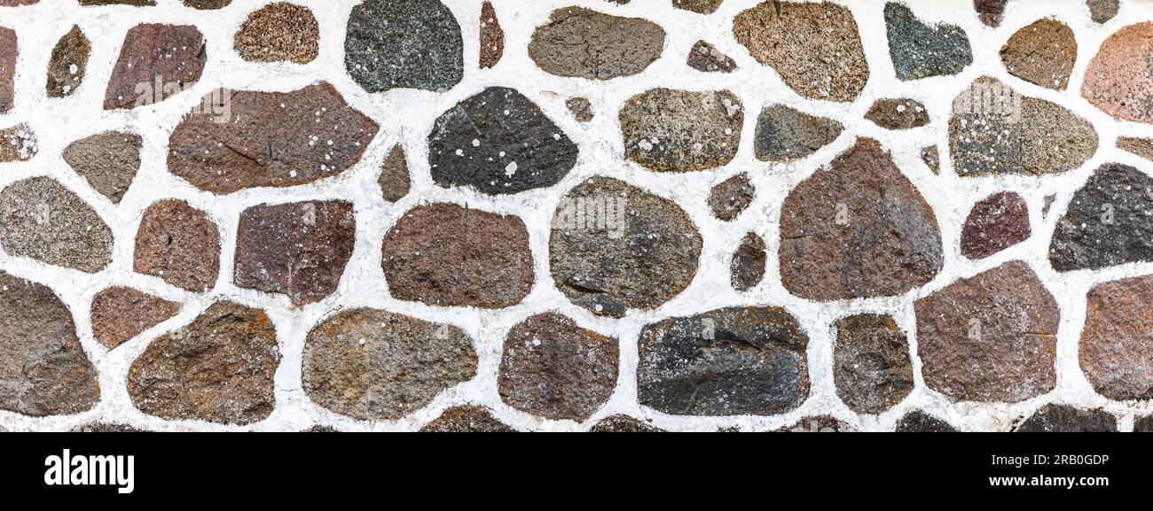 Mur en pierre naturelle en pierres de granit et mortier blanc Banque D'Images