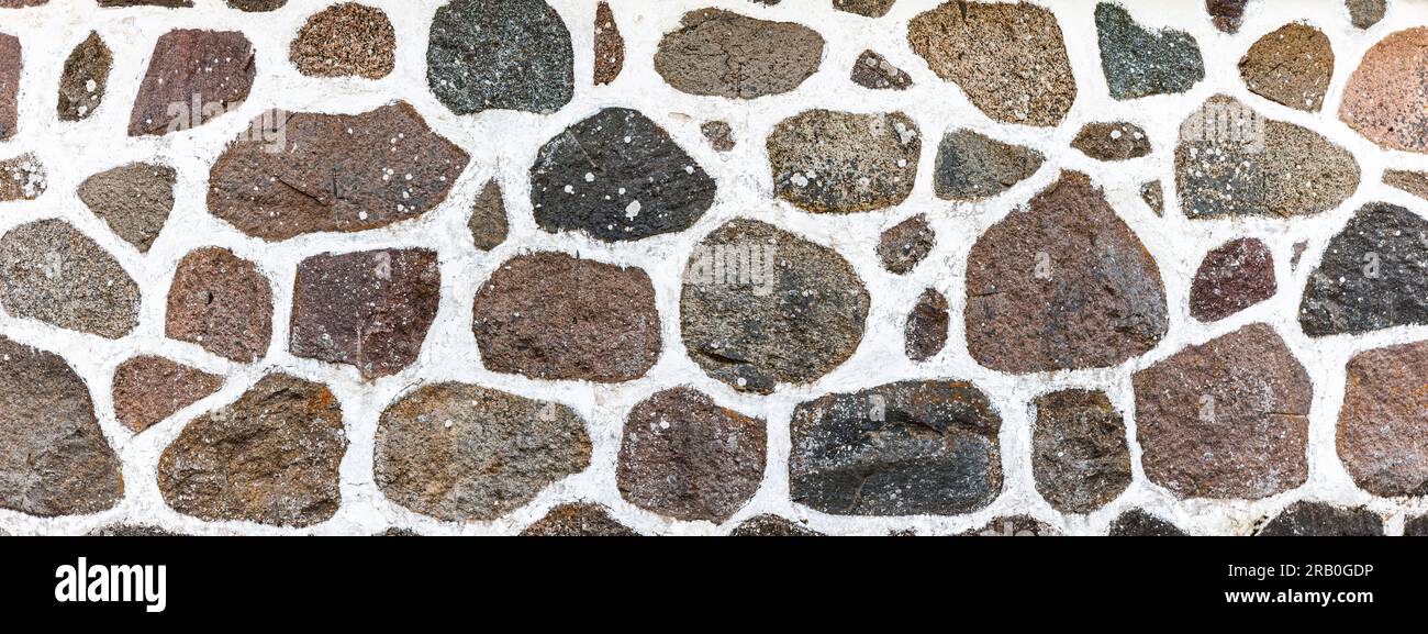 Mur en pierre naturelle fait de pierres de granit et de mortier blanc — free download