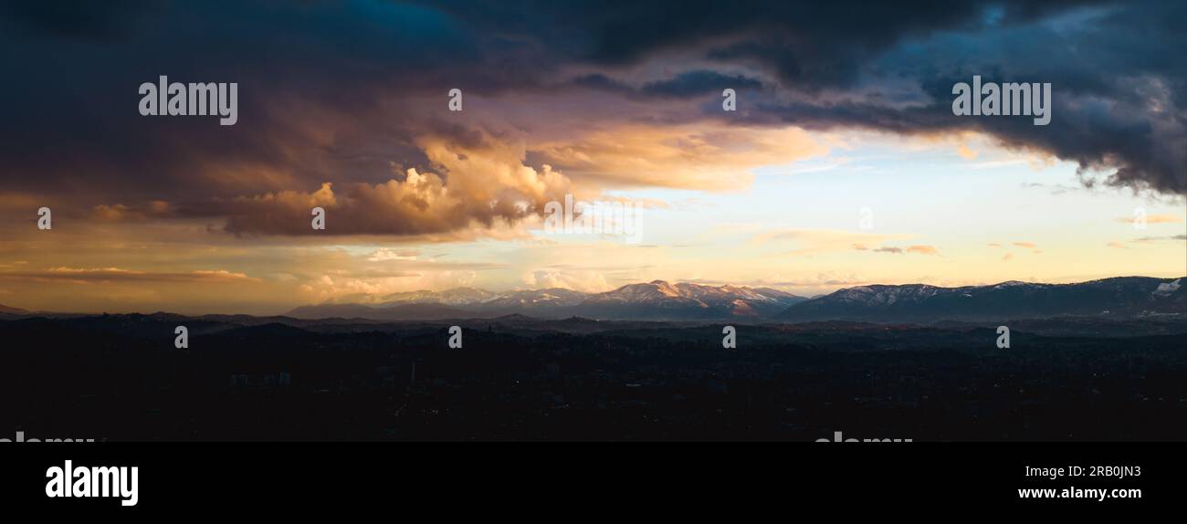 Superbe vue panoramique sur une chaîne de montagnes enneigées lors d'un magnifique coucher de soleil. Banque D'Images