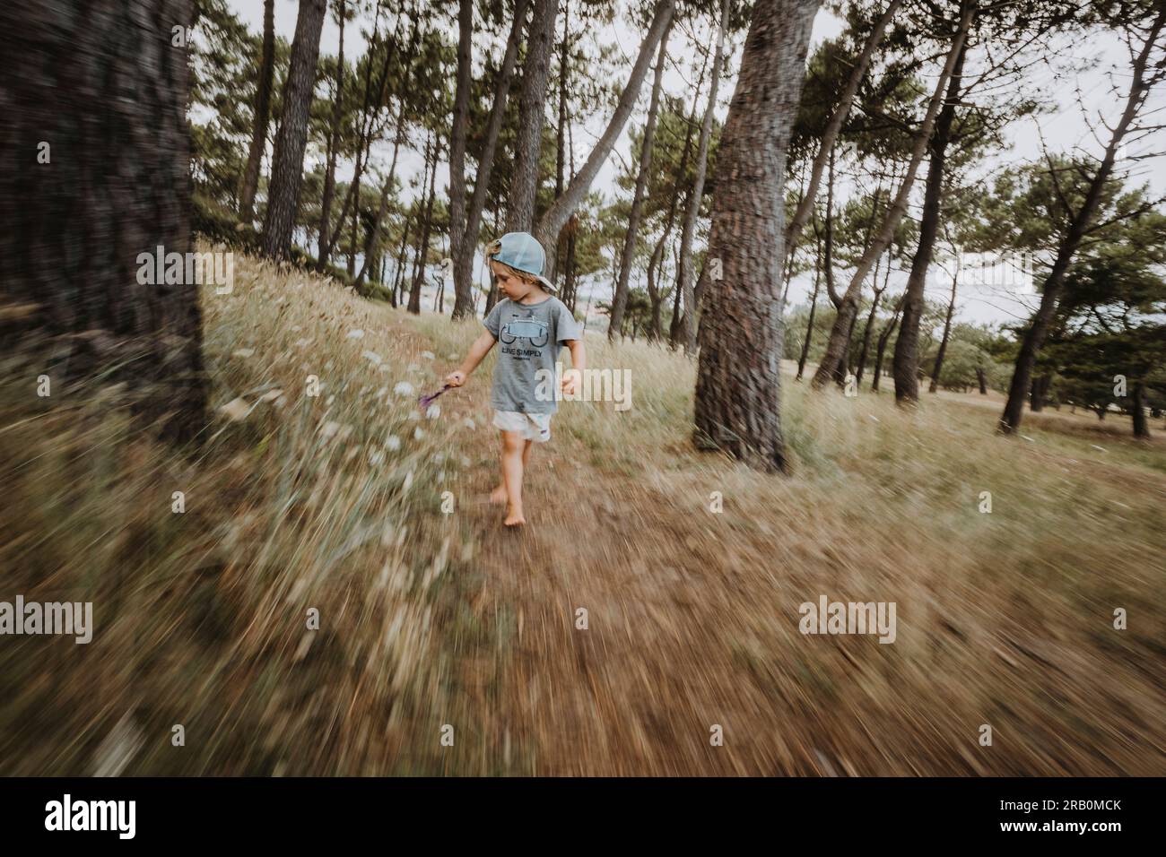 Boy running through forest Banque D'Images