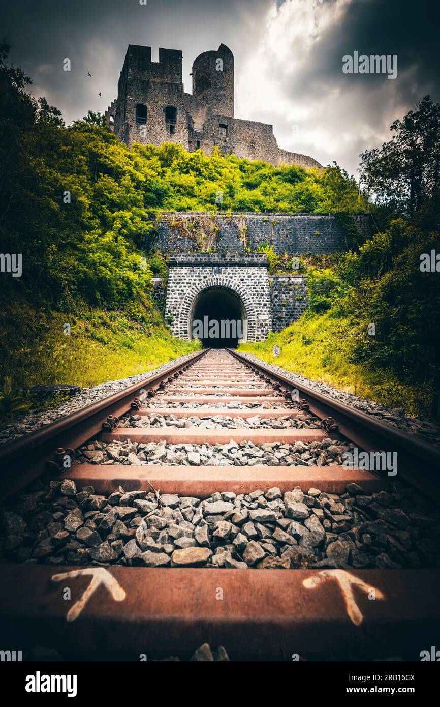 Voies ferrées menant avec un tunnel sous un château, Löwenburg, Monreal, Rhénanie-Palatinat, Allemagne Banque D'Images