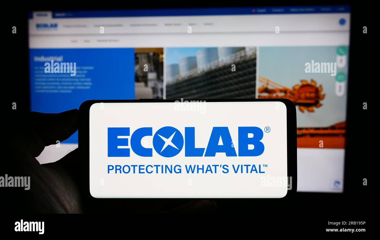 Personne tenant le téléphone portable avec le logo de la société américaine de technologie de l'eau Ecolab Inc. Sur l'écran devant la page Web d'affaires. Concentrez-vous sur l'affichage du téléphone. Banque D'Images