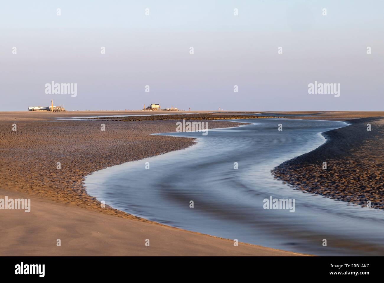 Vue sur St. Peter Ording plage au coucher du soleil avec un tideway à marée basse Banque D'Images