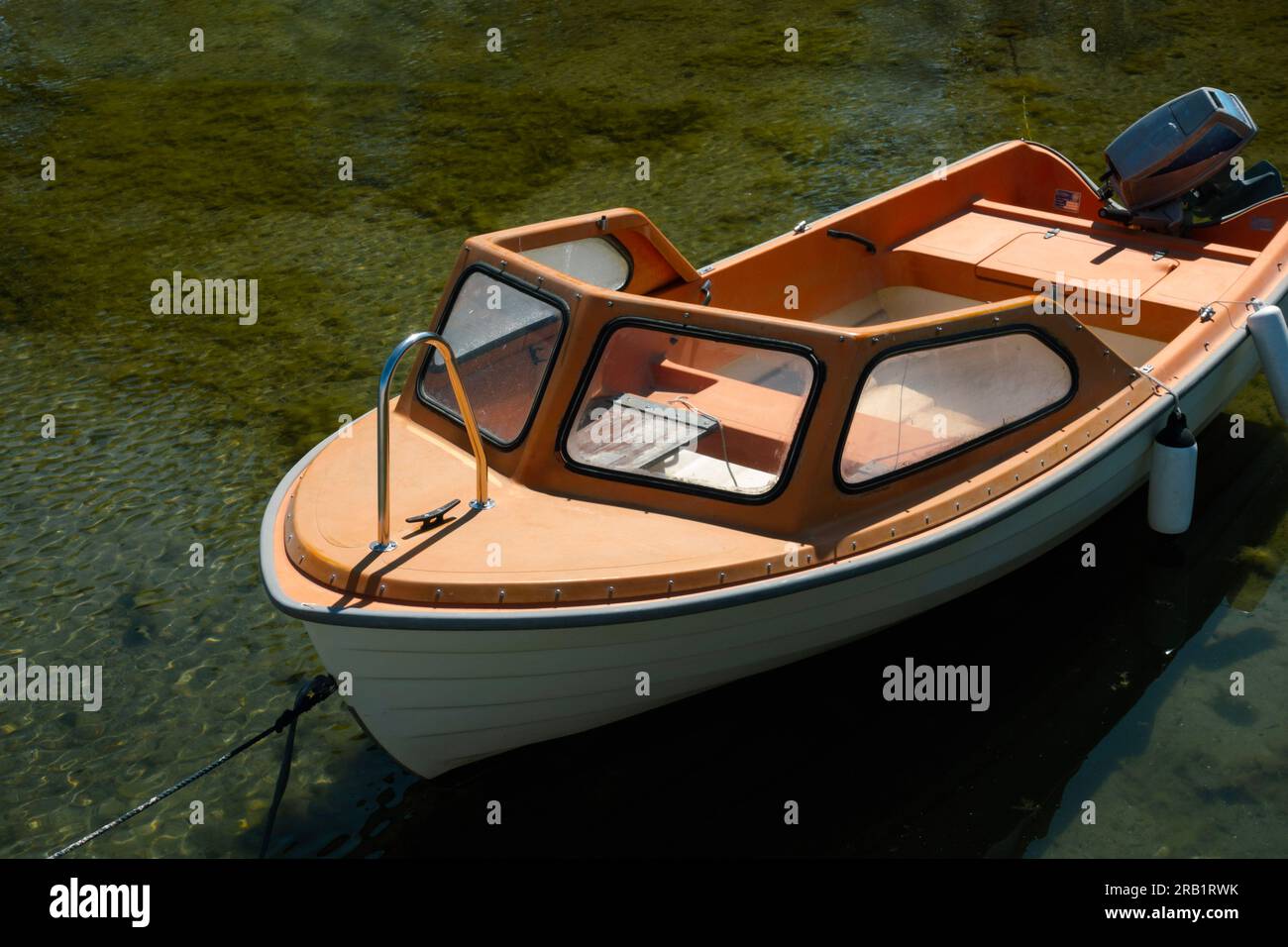 Petit vieux bateau à moteur amarré dans l'eau claire pour le concept de loisirs d'été Banque D'Images