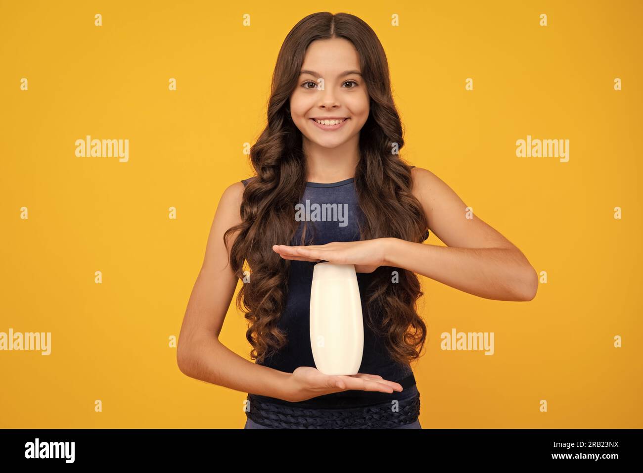 Enfant avec après shampooing. Soins cosmétiques quotidiens. L'adolescent de 12, 13, 14 ans tient une bouteille de soins pour les cheveux et la peau. Beauté santé et cosmétiques. Banque D'Images