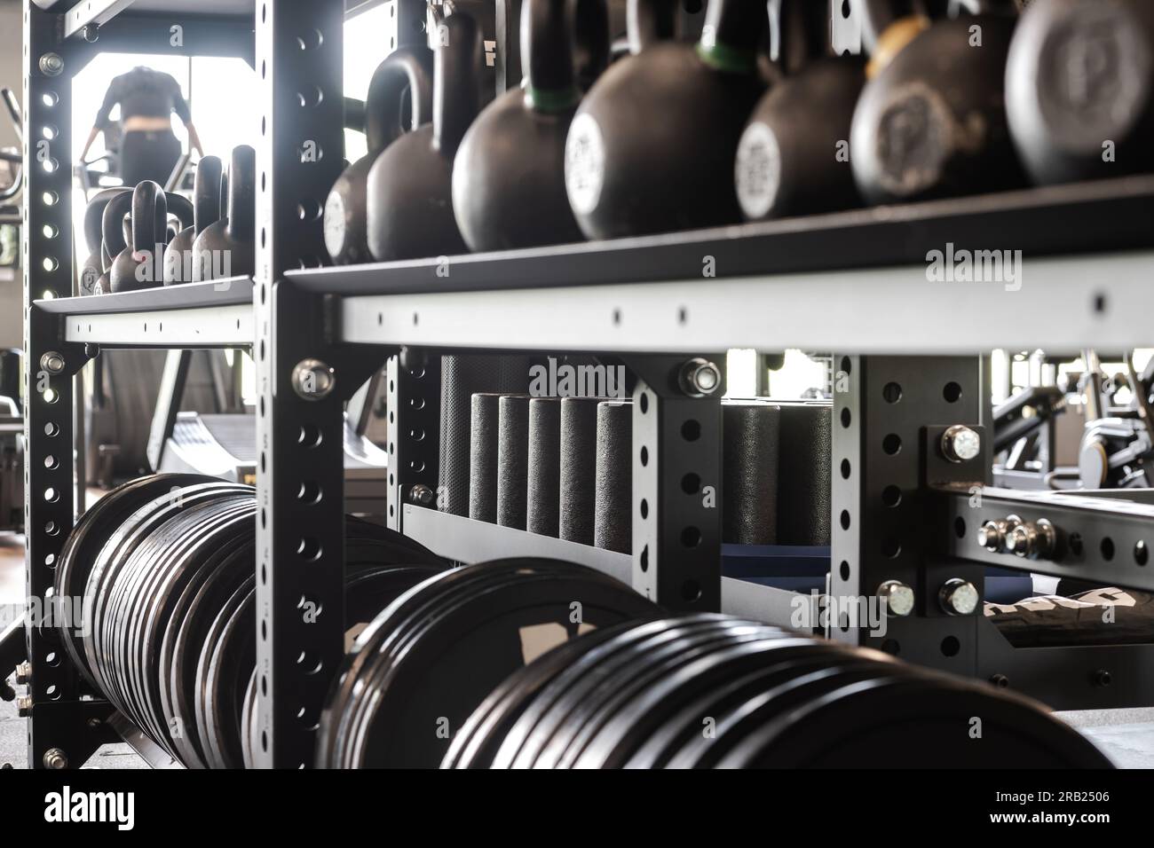 Gros plan de l'étagère d'équipement de gym avec kettlebells, plaque de poids et rouleaux de massage pour l'entraînement de force. Style de vie sain et thème de remise en forme. Banque D'Images