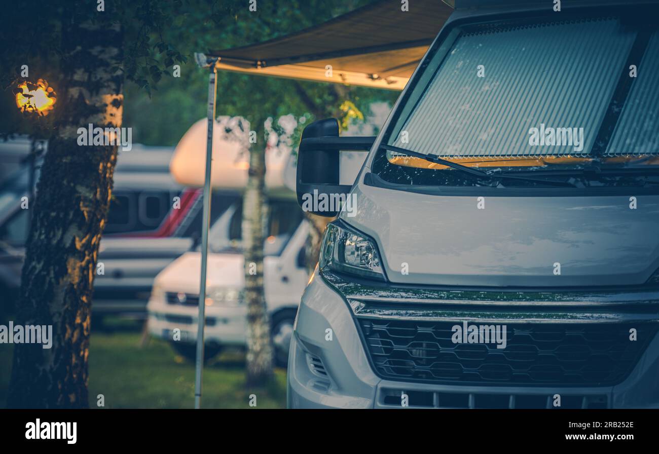 Gros plan du camping-car blanc moderne avec auvent déployé garé au camping RV pour la nuit. Thème Camping et camping-car. Banque D'Images