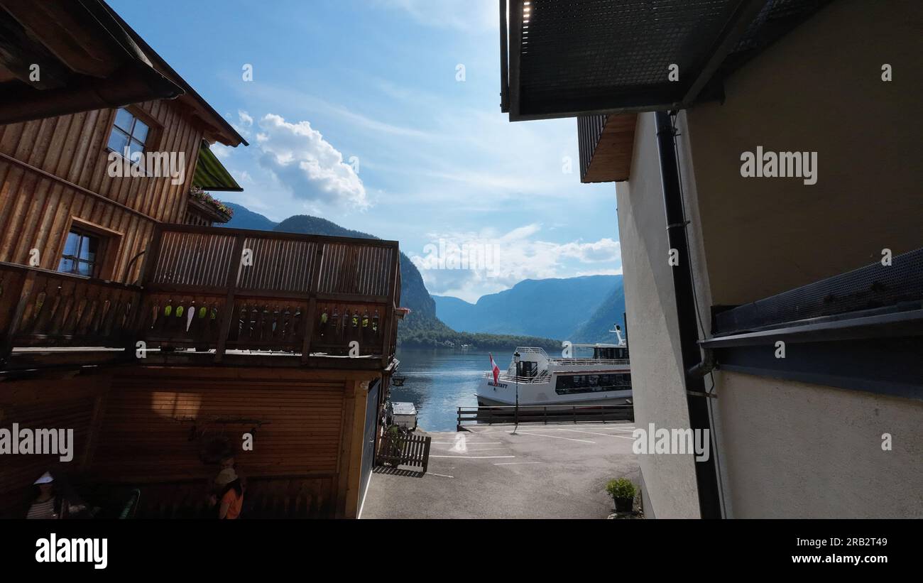 Maison en bois, lac et bateau dans la ville de Hallstatt. Hallstatt, Autriche - 7 juin 2023 Banque D'Images