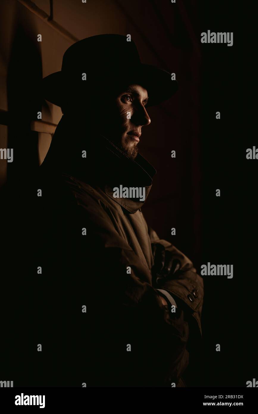 homme mafia détective dans un chapeau et imperméable dans une ville de nuit dans le style de film noir Banque D'Images