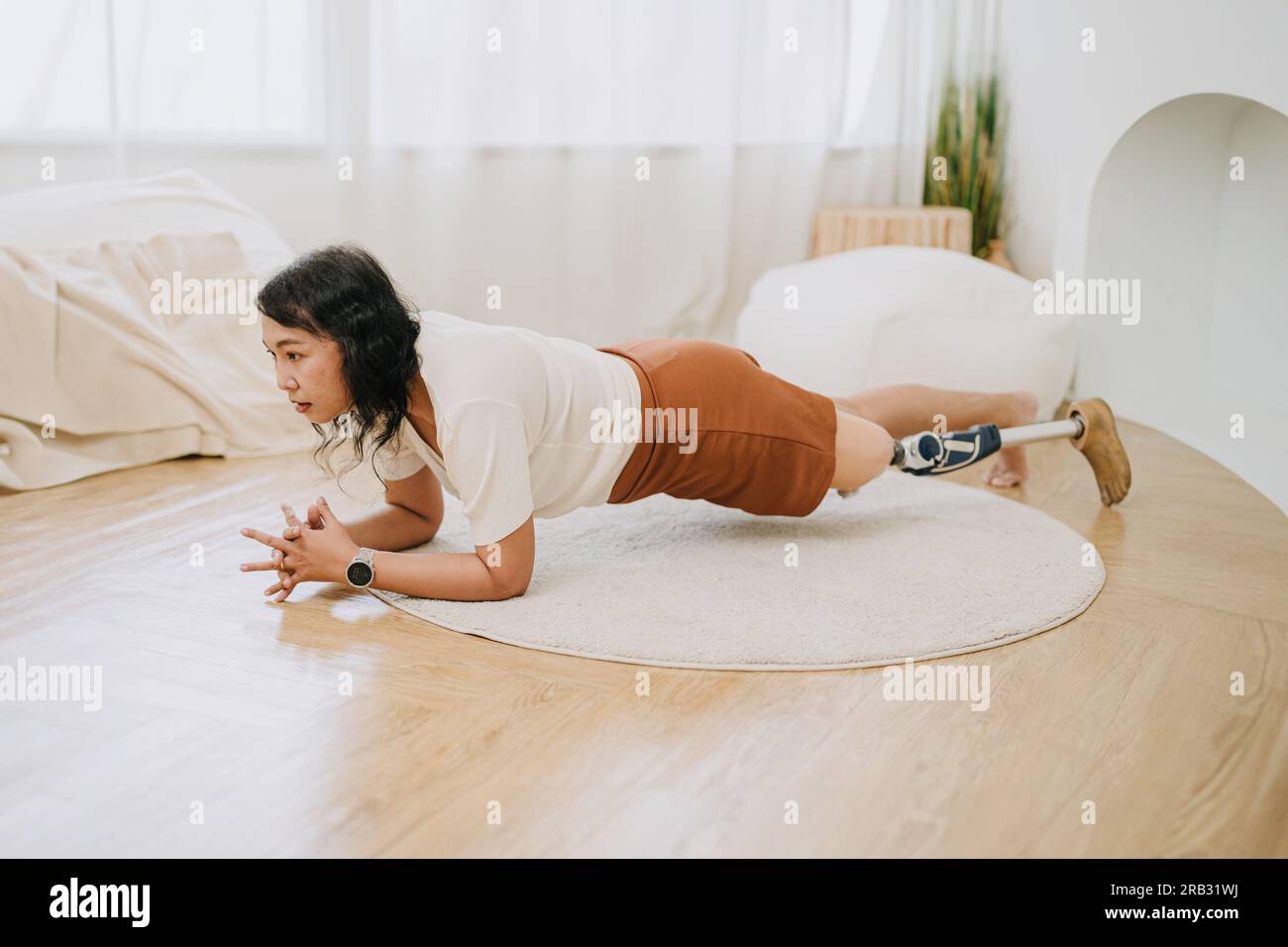 prothèse de jambe les personnes formant des planches font de l'exercice à la maison. handicap asiatique femme activité de soins de santé à l'intérieur. Banque D'Images