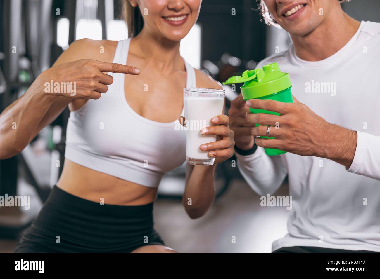 les personnes en bonne santé de sport montrent comparer le lait et le shake de protéine de lactosérum sont un bon repas alimentaire de boisson pour gagner le bodybuilding de muscle de corps de masse Banque D'Images