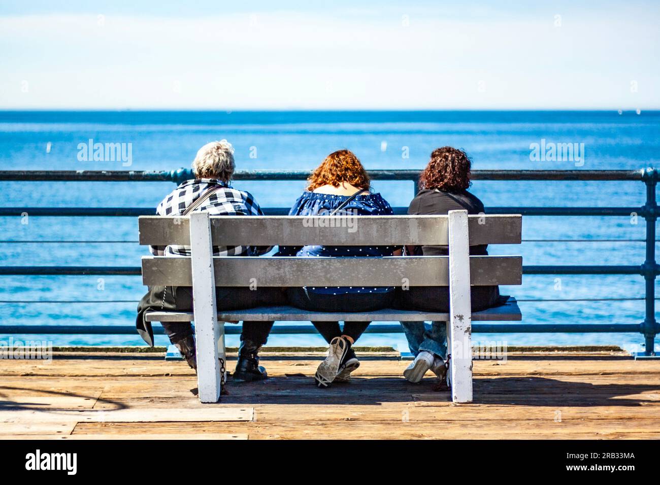 Trois femmes âgées assises ensemble sur un banc Banque D'Images