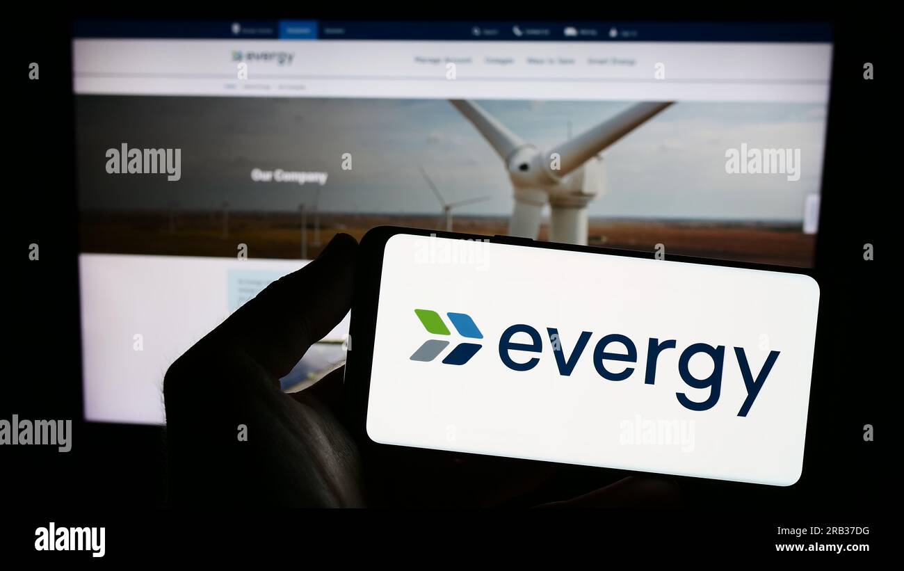 Personne tenant un smartphone avec le logo de la société de services publics américaine Evergy Inc. Sur l'écran devant le site Web. Concentrez-vous sur l'affichage du téléphone. Banque D'Images