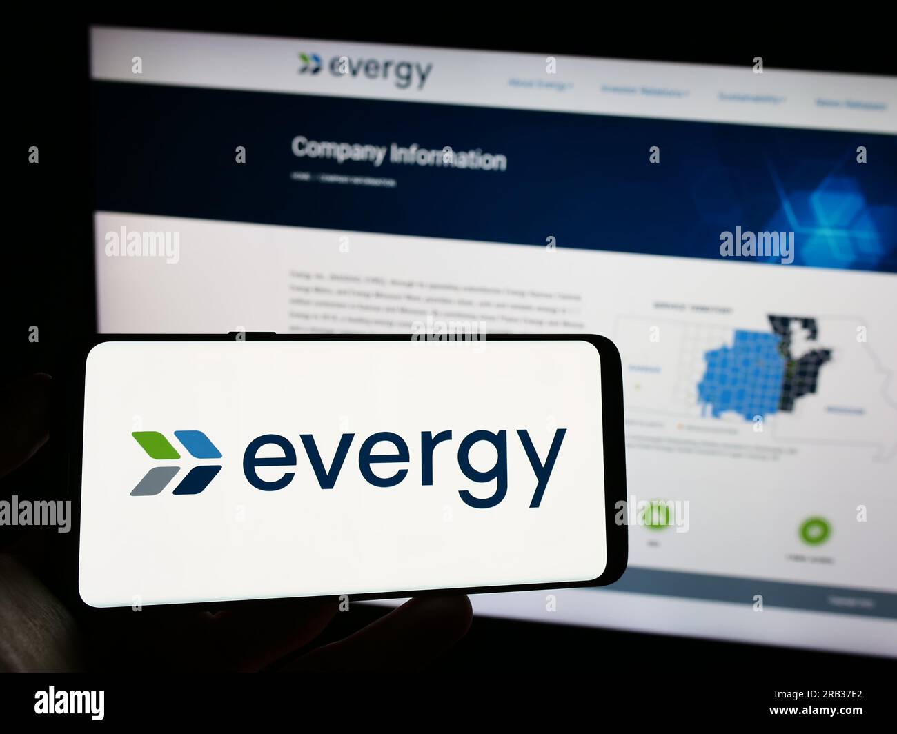 Personne tenant le téléphone portable avec le logo de la société de services publics américaine Evergy Inc. Sur l'écran devant la page Web de l'entreprise. Concentrez-vous sur l'affichage du téléphone. Banque D'Images
