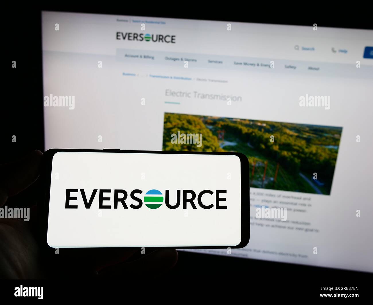 Personne tenant le smartphone avec le logo de la société de services publics américaine Eversource Energy sur l'écran en face du site Web. Concentrez-vous sur l'affichage du téléphone. Banque D'Images