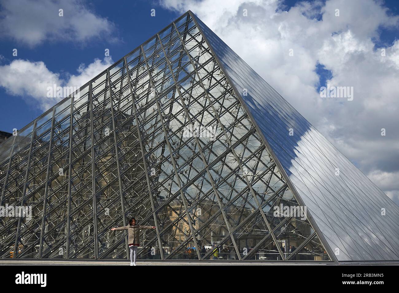 Fille asiatique posant dans le bâtiment de pyramide de verre devant au musée du Louvre Banque D'Images