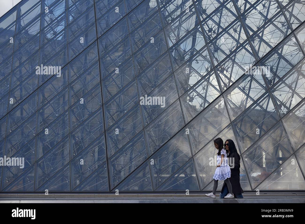 Fille asiatique et mère au bâtiment de pyramide de verre au musée du Louvre Banque D'Images