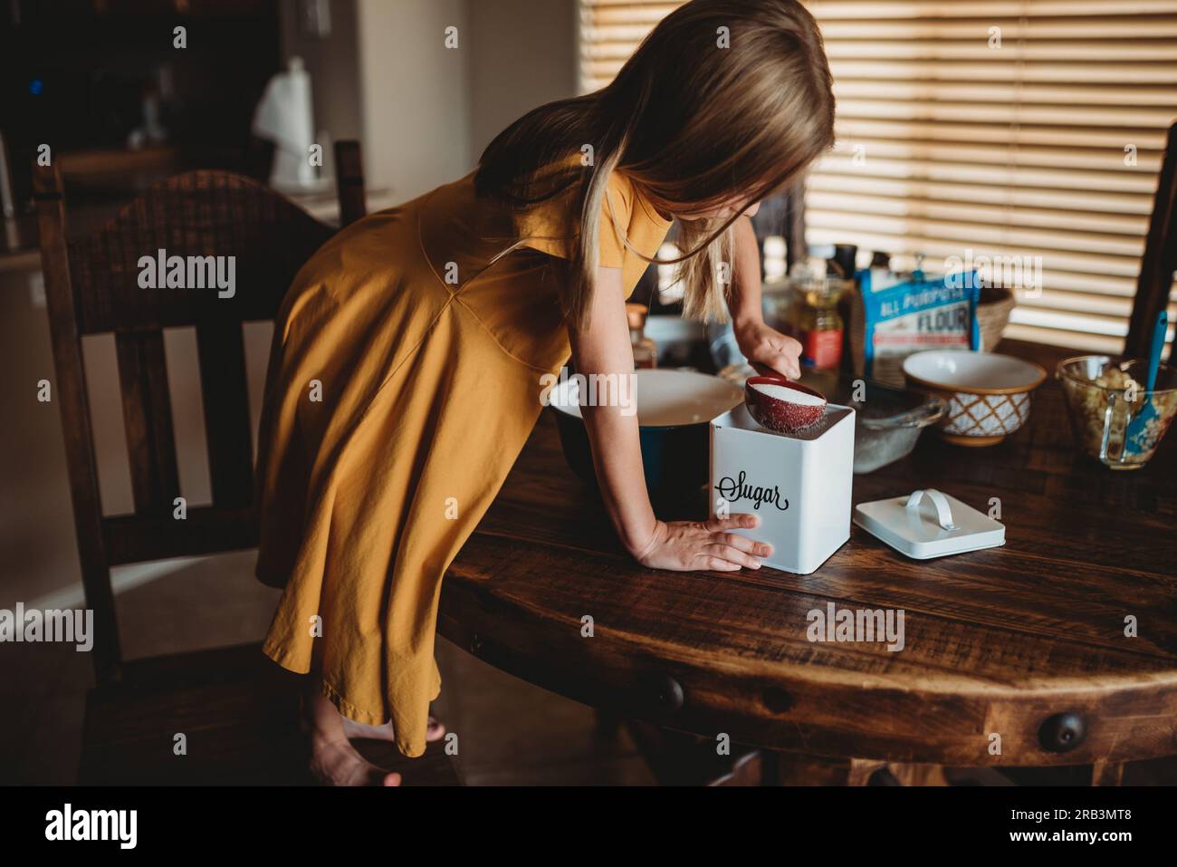 Fille à table préparant la nourriture Banque D'Images