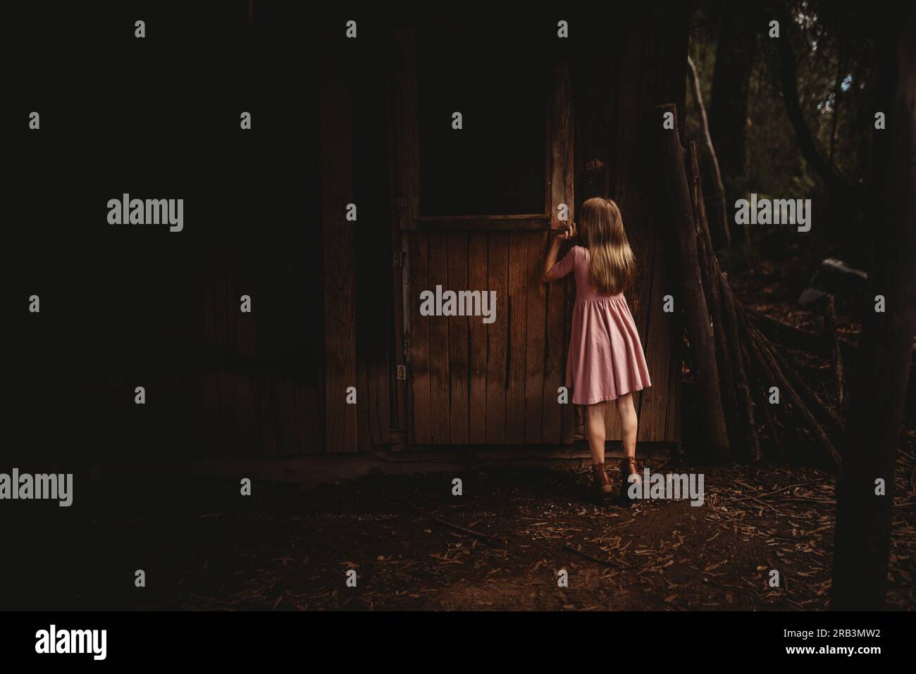 Fille jetant un coup d'œil par une fenêtre Banque D'Images