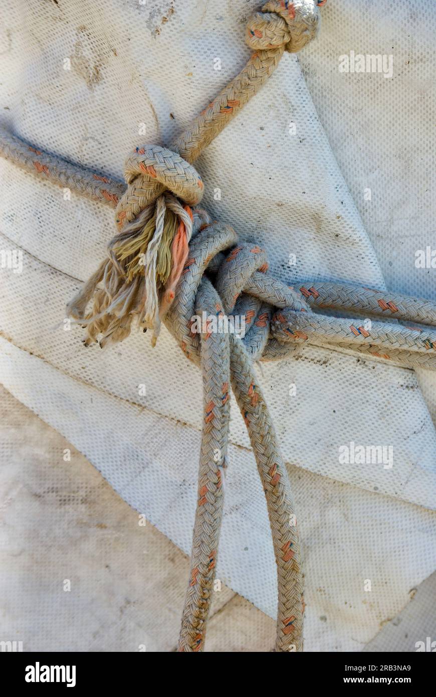 Gros plan d'une corde nouée couchée sur une bâche dans un bateau de pêche. Banque D'Images