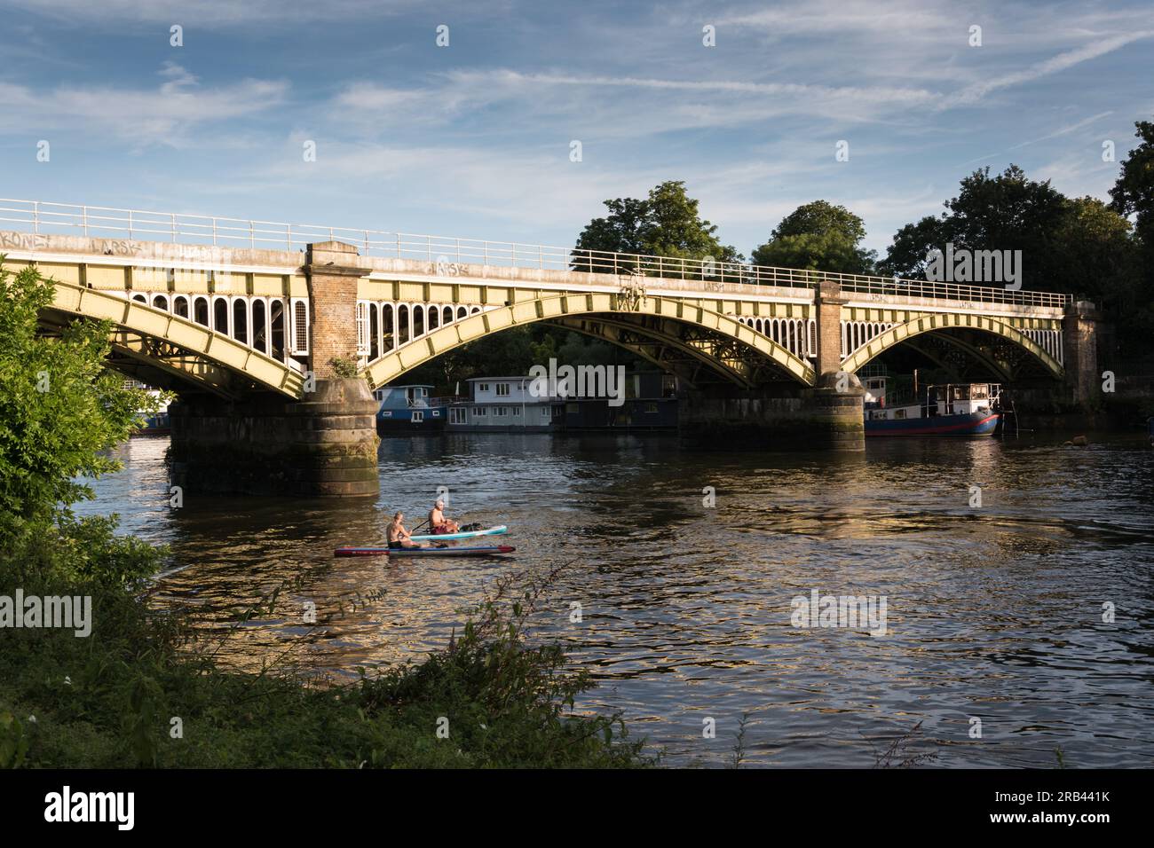 Deux hommes pagayant en kayak sous le pont ferroviaire Richmond sur la Tamise, Londres, Angleterre, Royaume-Uni Banque D'Images