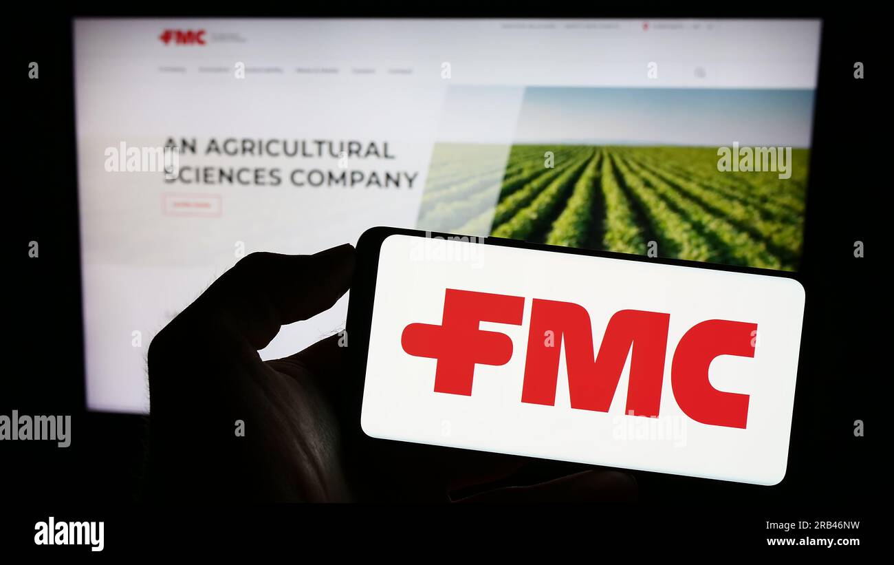 Personne tenant un smartphone avec le logo de la société chimique américaine FMC Corporation sur l'écran devant le site Web. Concentrez-vous sur l'affichage du téléphone. Banque D'Images