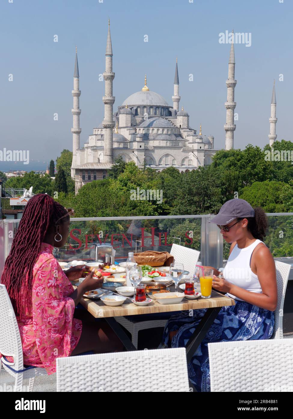 Deux personnes dînent à la terrasse du restaurant Seven Hills avec la mosquée Sultan Ahmed alias Mosquée Bleue derrière, Sultanahmet, Istanbul, Turquie. Banque D'Images