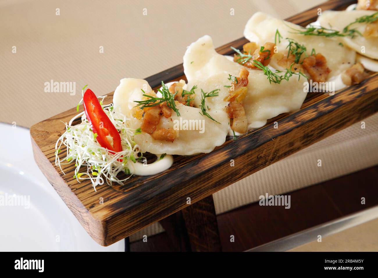 Boulettes avec pommes de terre et salade. Boulettes aux pommes de terre et aux cretons à la crème sure sur une planche en bois et salade. Banque D'Images