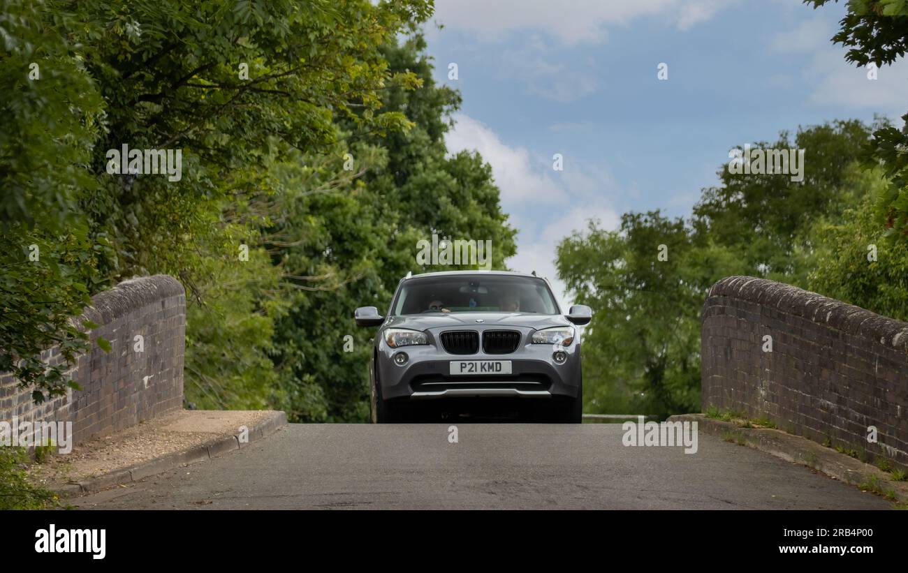 Milton Keynes, Royaume-Uni - 6 juillet 2023 : 2011 BMW X1 sur un pont étroit, bosse arrière Banque D'Images