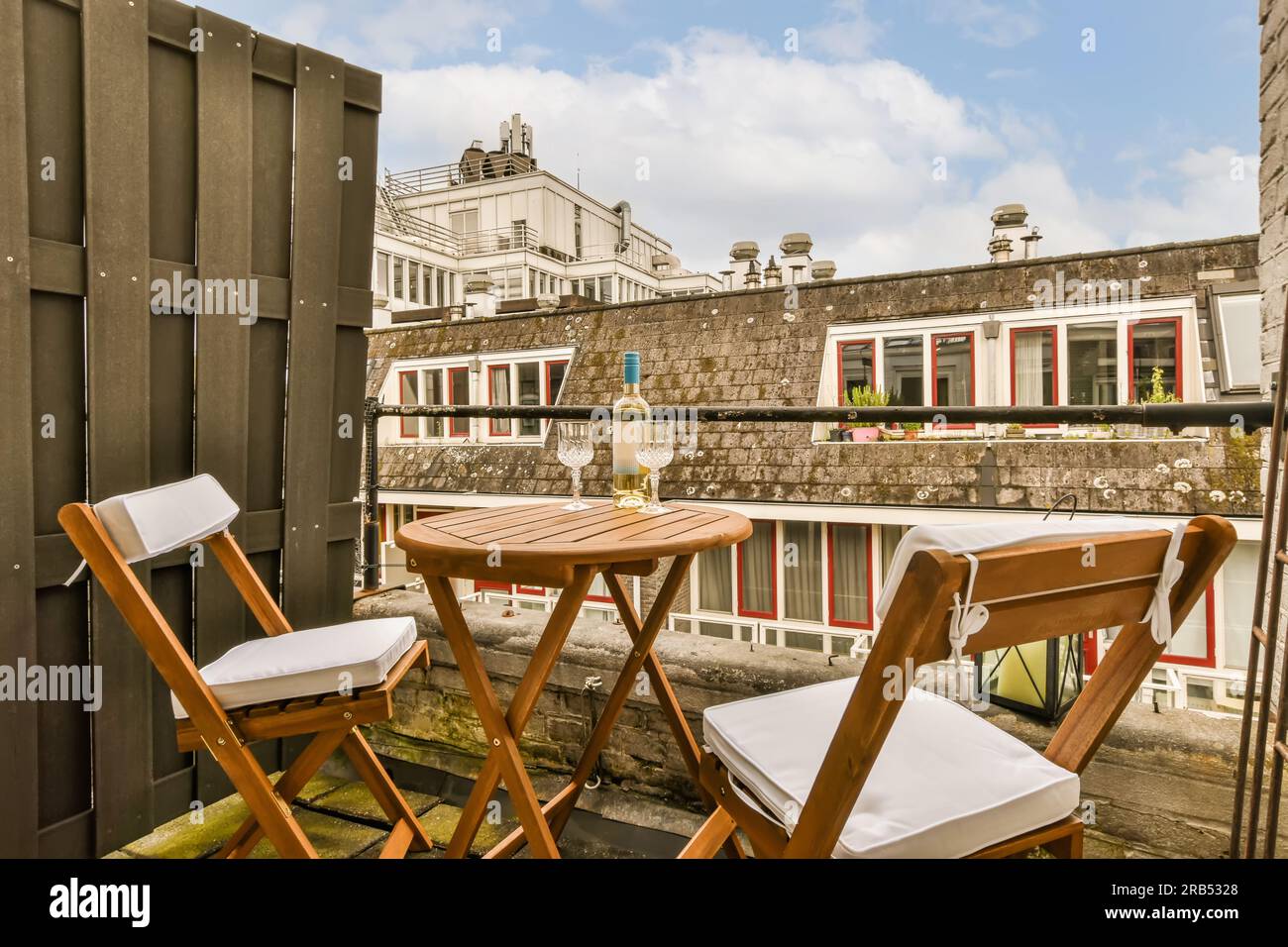un balcon avec deux chaises et une table en face d'un bâtiment qui  ressemble à un café ou un restaurant en plein air Photo Stock - Alamy