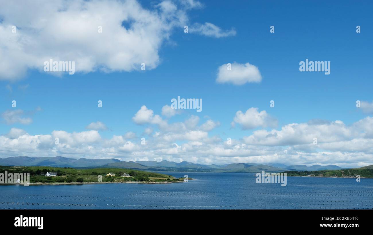 Vue depuis la péninsule de Beara à travers Kenmare Bay vers les montagnes du comté de Kerry. Veuillez noter la grande ferme de moules au premier plan Banque D'Images