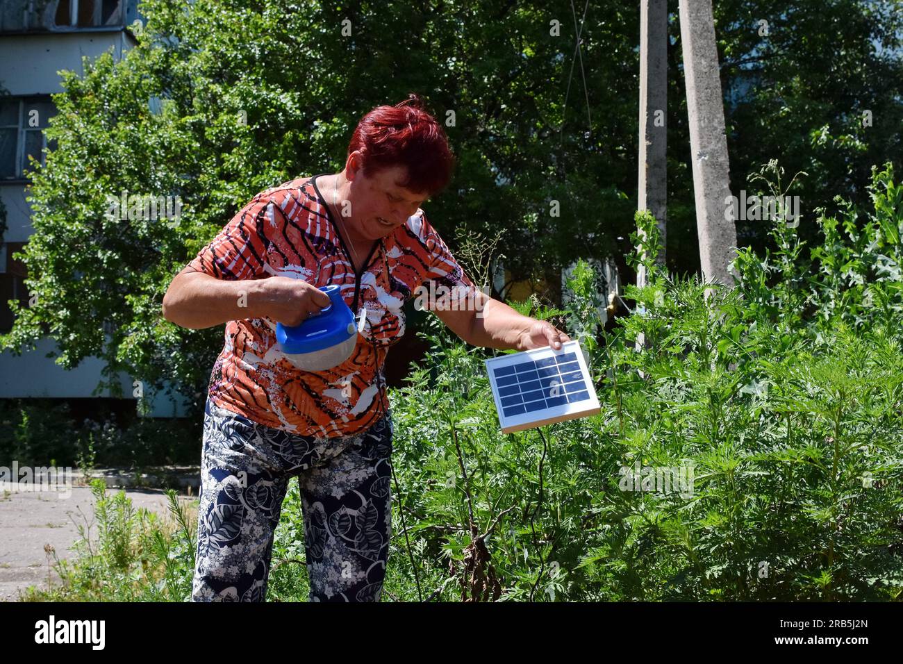 Huliaipole, Ukraine. 06 juillet 2023. Une femme voyant sur la cour arrière de sa maison charger la lampe avec un panneau solaire à Huliaipole. Les forces russes sur les fronts de Zaporizhzhia et de Kherson concentrent leurs efforts sur la prévention de l'avancée des forces ukrainiennes. Crédit : SOPA Images Limited/Alamy Live News Banque D'Images