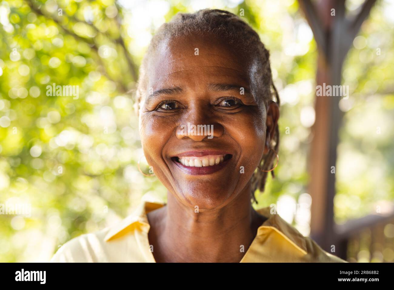 Portrait de femme afro-américaine senior heureuse dans la nature ensoleillée. Style de vie senior, détente, retraite et bien-être dans la nature, inchangé. Banque D'Images