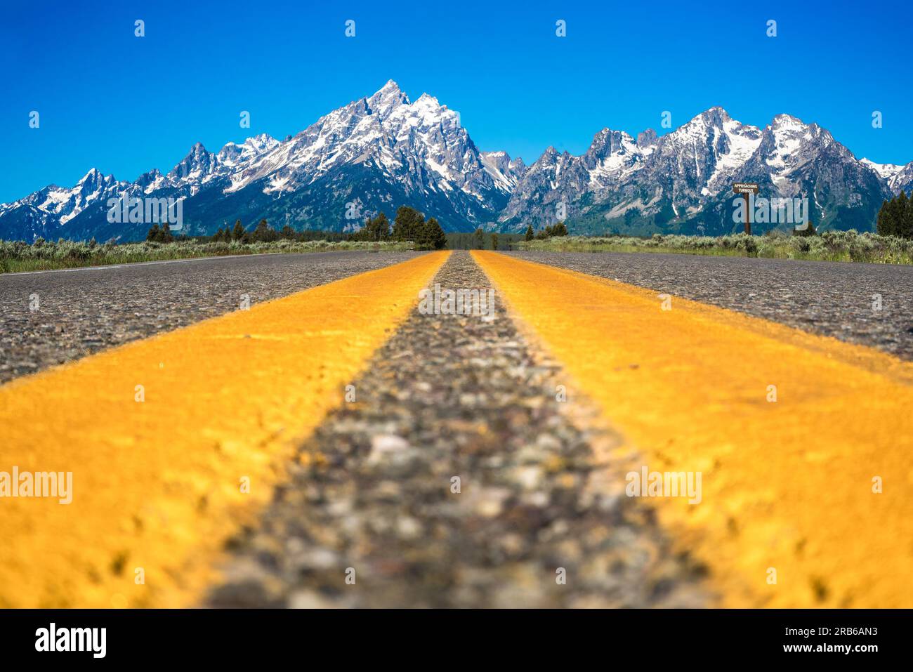Route jaune divisant les lignes avec beau paysage du parc national de Grand Teton Banque D'Images