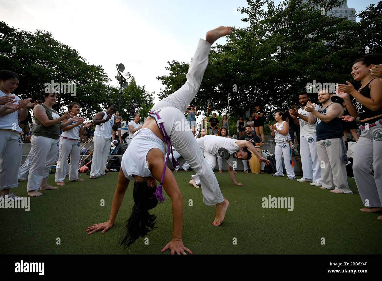 New York, États-Unis. 07 juillet 2023. Un groupe de personnes exécute l'art martial afro-brésilien de Capoeira dans Hunter's point South Park, dans le Queens Borough de New York, NY, juillet 7. 2023. La capoeira est un art martial afro-brésilien avec des éléments de danse et des acrobaties jouées avec de la musique. (Photo Anthony Behar/Sipa USA) crédit : SIPA USA/Alamy Live News Banque D'Images