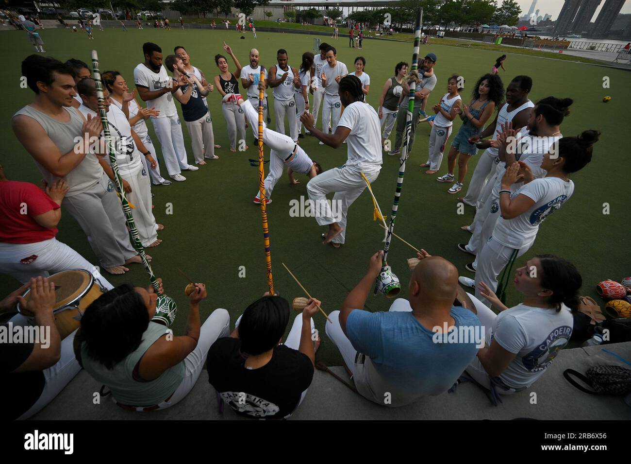 New York, États-Unis. 07 juillet 2023. Un groupe de personnes exécute l'art martial afro-brésilien de Capoeira dans Hunter's point South Park, dans le Queens Borough de New York, NY, juillet 7. 2023. La capoeira est un art martial afro-brésilien avec des éléments de danse et des acrobaties jouées avec de la musique. (Photo Anthony Behar/Sipa USA) crédit : SIPA USA/Alamy Live News Banque D'Images