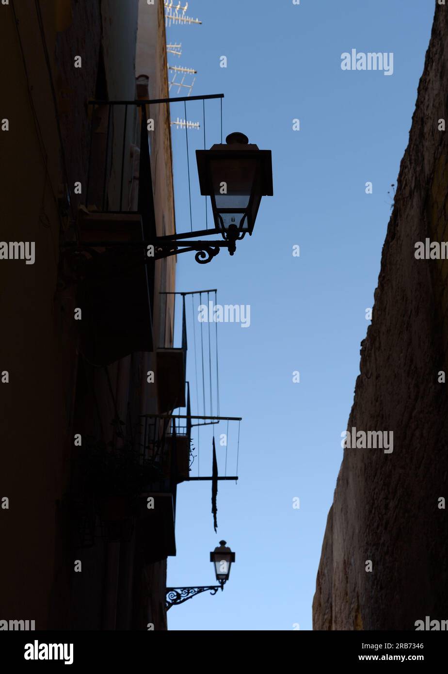 Vieux bâtiments avec des lampes sur une rue étroite en Italie. Banque D'Images