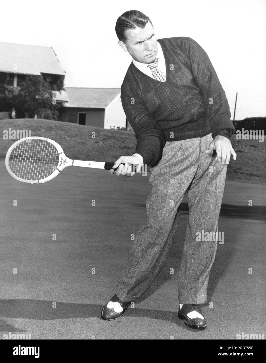 New Jersey : c. 1953 Un homme posant avec différents équipements de sport et montrant les similitudes de posture du corps. Ici, il utilise une raquette de tennis.. Banque D'Images