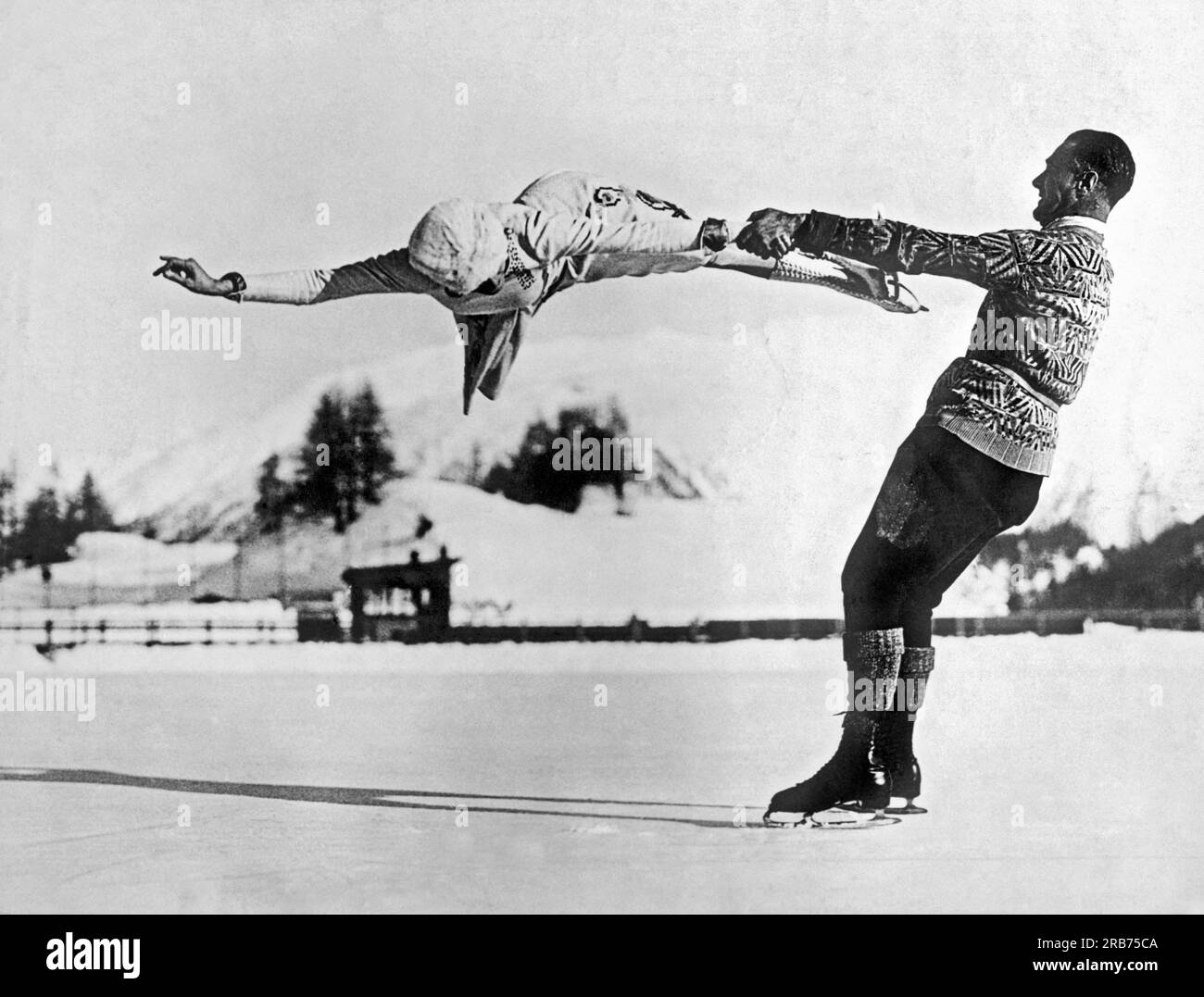 St. Moritz, Suisse : c. 1935. Les patineurs artistiques New-yorkais de renommée mondiale Freda Whitaker et Phil Taylor montrent des acrobaties étonnantes alors qu'ils se préparent pour les prochains Jeux olympiques d'hiver. Banque D'Images