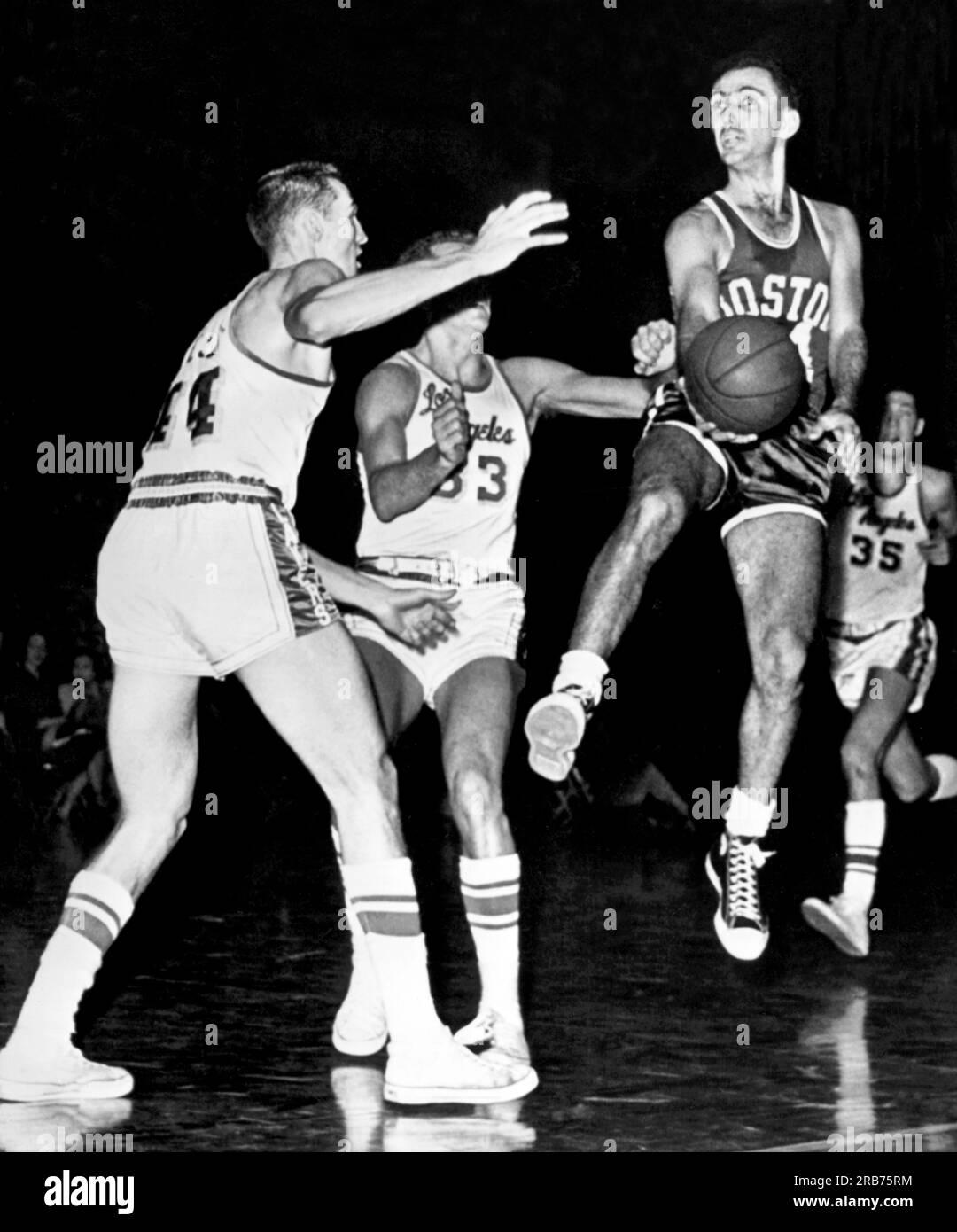 St. Louis, Missouri : 14 février 1961 Bob Cousy des Celtics de Boston en plein air sur le point de passer à un coéquipier alors que les joueurs des Lakers de Los Angeles Jerry West (44) et Rod Hundley (33) se rapprochaient de lui. C'est le premier match d'un double-header NBA à Saint-Louis. Banque D'Images