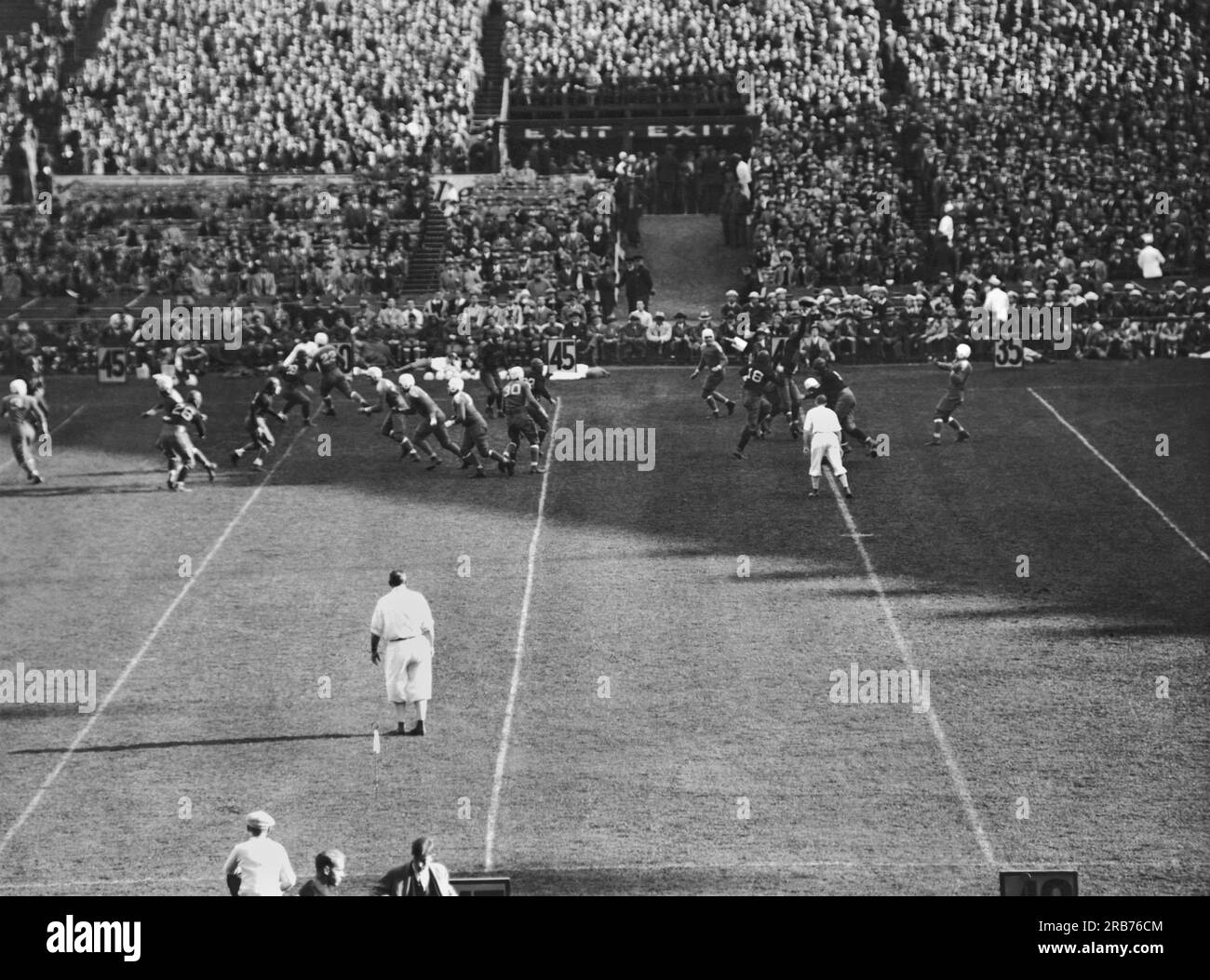 New York, New York : c. 1915 le quarterback à l'extrême droite regarde sa passe se faire renverser par un membre de la ligne offensive de l'équipe adverse lors d'un match au Yankee Stadium. Banque D'Images