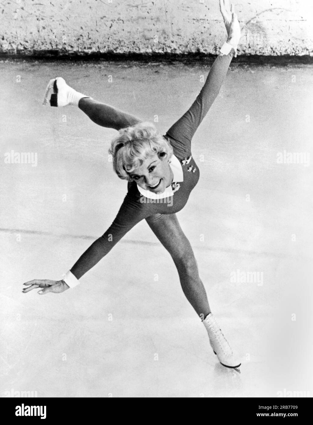 c. 1955. Sonia Henie, patineuse de championnat et actrice, montre son style remarquable et gracieux dans cette photographie. Banque D'Images