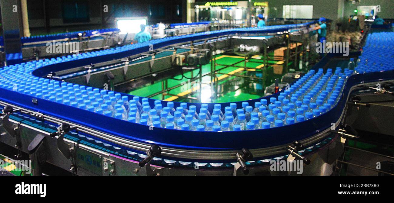 ANQING, CHINE - 8 JUILLET 2023 - les travailleurs se précipitent pour fabriquer de l'eau embouteillée à l'atelier de production d'une entreprise de boissons dans la zone de développement économique de Banque D'Images
