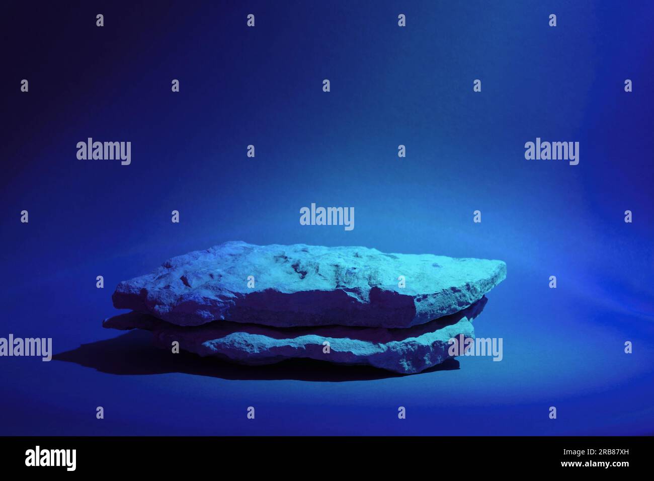 Pierre Podium pour promotion sur fond holographique de couleur néon. Socle naturel en pierre. Deux podiums de pierre. Maquette de produit de beauté. Scène pour afficher prod Banque D'Images